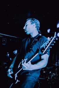 a man playing a guitar in a dark room