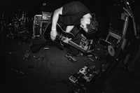 a black and white photo of a man playing a guitar