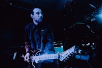 a man playing a guitar in a dark room