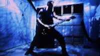 a man playing a guitar in a dark room