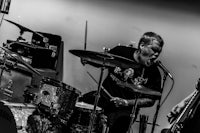 a black and white photo of two men playing drums