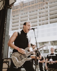 a man playing an electric guitar in front of a crowd