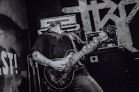 a black and white photo of a man playing a guitar