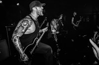 a black and white photo of a band with tattoos